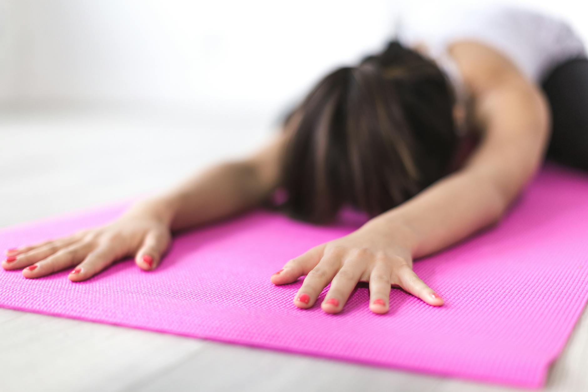Close up of hands stretching on a yoga mat